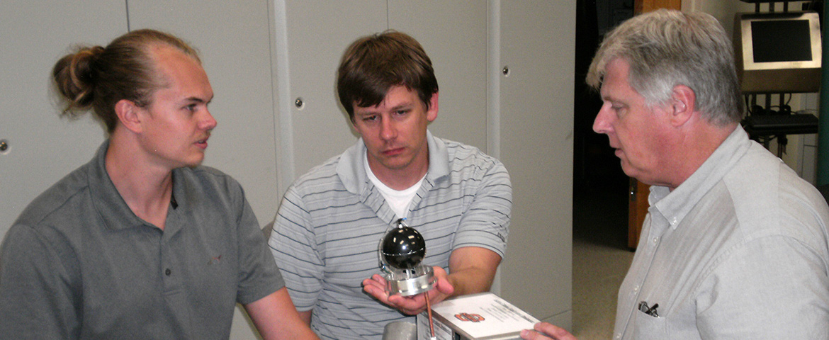 Dr. Eric Benton (right) works with graduate students on his radiation detector.