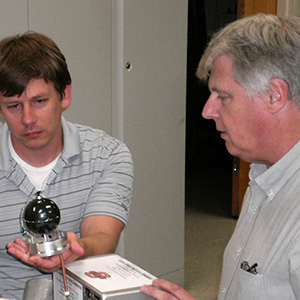 Dr. Eric Benton (right) works with graduate students on his radiation detector.